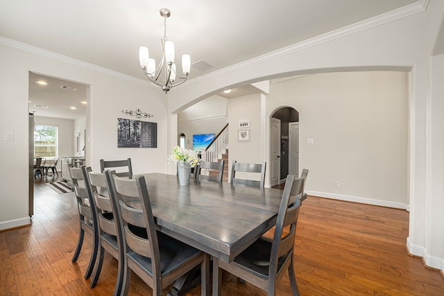 300 Bentside Pl, Clute, TX 77531 - dining room with a chandelier, hardwood / wood-style floors, stairway, arched walkways, and crown molding