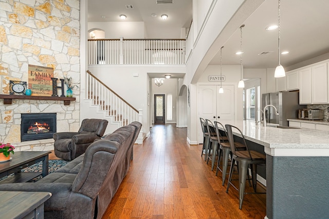 300 Bentside Pl, Clute, TX 77531 - living area with wood finished floors, a fireplace, stairway, and arched walkways