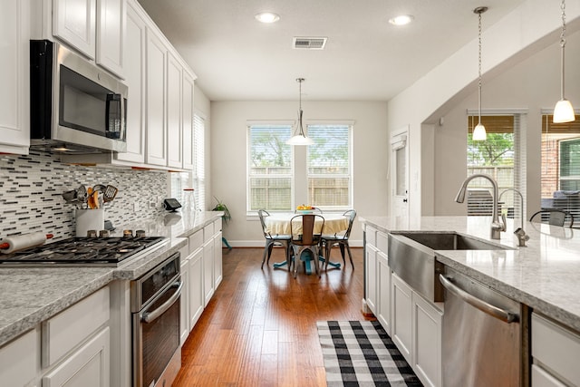 300 Bentside Pl, Clute, TX 77531 - kitchen featuring stainless steel appliances, a sink, healthy amount of natural light, decorative backsplash, and recessed lighting