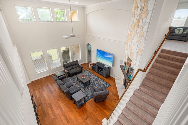 300 Bentside Pl, Clute, TX 77531 - living room featuring wood finished floors, a ceiling fan, stairs, baseboards, and ornamental molding