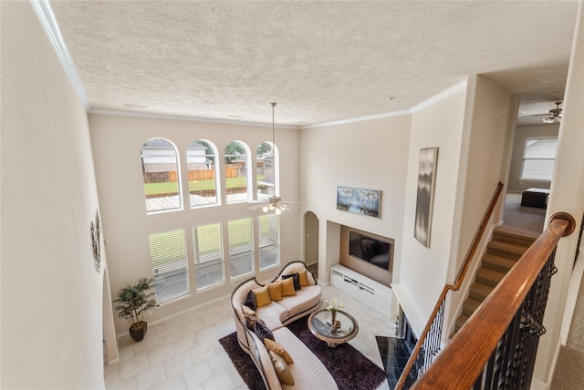 4610 Countrymeadows Dr, Spring, TX 77388 - living room featuring a ceiling fan, healthy amount of natural light, ornamental molding, tile patterned floors, and a textured ceiling