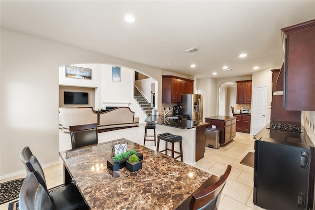 4610 Countrymeadows Dr, Spring, TX 77388 - dining space featuring arched walkways, recessed lighting, stairs, and light tile patterned floors