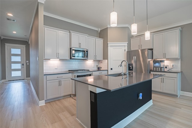 14424 Tunnel Tree Ct, Conroe, TX 77384 - kitchen featuring appliances with stainless steel finishes, a sink, dark countertops, ornamental molding, and light wood-type flooring