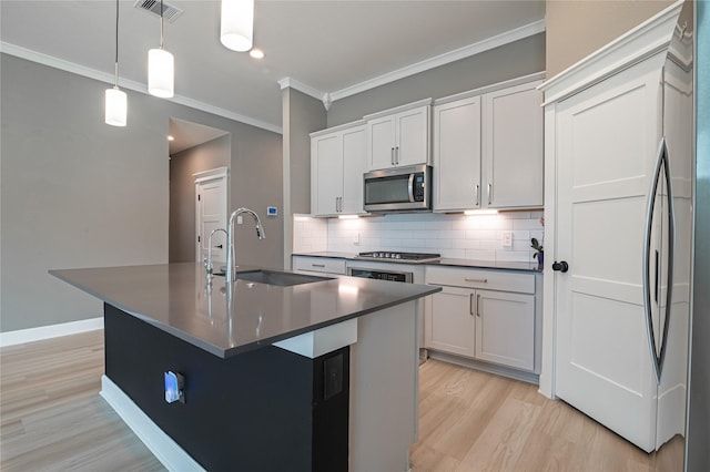 14424 Tunnel Tree Ct, Conroe, TX 77384 - kitchen featuring appliances with stainless steel finishes, light wood-style flooring, a sink, dark countertops, and decorative backsplash