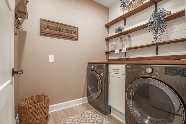 14424 Tunnel Tree Ct, Conroe, TX 77384 - laundry room with washer and dryer, light wood finished floors, and baseboards