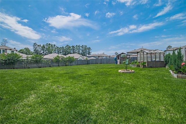 14424 Tunnel Tree Ct, Conroe, TX 77384 - view of yard featuring a greenhouse, an outbuilding, a residential view, and a vegetable garden