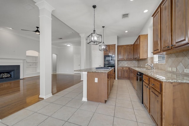 3935 Waverly Bnd, Katy, TX 77450 - kitchen featuring open floor plan, brown cabinetry, black appliances, decorative columns, and ornamental molding