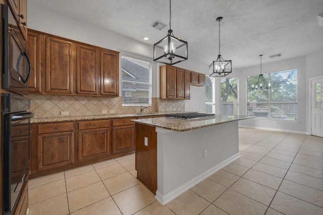 3935 Waverly Bnd, Katy, TX 77450 - kitchen featuring a chandelier, light tile patterned floors, decorative backsplash, black appliances, and light stone countertops