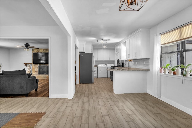 1103 Glenmore Dr, Pasadena, TX 77503 - kitchen featuring separate washer and dryer, freestanding refrigerator, open floor plan, white cabinets, and light wood-style flooring