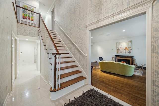 2628 Glen Haven Blvd, Houston, TX 77025 - stairway featuring wallpapered walls, a fireplace, and tile patterned flooring