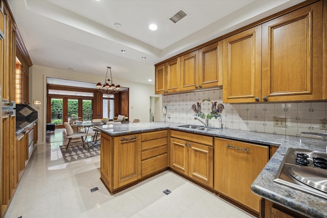 2628 Glen Haven Blvd, Houston, TX 77025 - kitchen with brown cabinets, stainless steel stovetop, a peninsula, backsplash, and recessed lighting