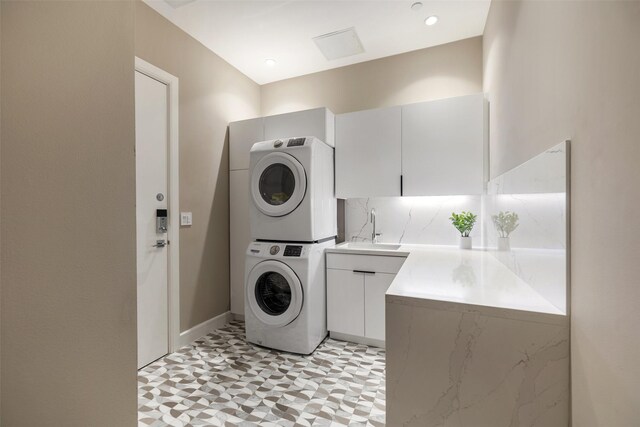 4521 San Felipe St Unit 1201, Houston, TX 77027 - laundry area featuring estacked washer and dryer, cabinet space, and baseboards