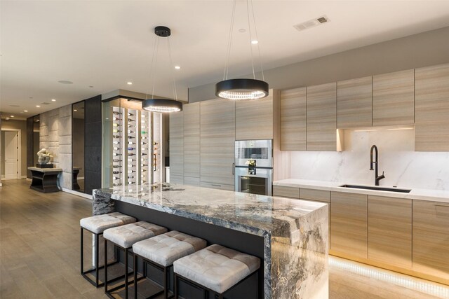 4521 San Felipe St Unit 1201, Houston, TX 77027 - kitchen with a sink, modern cabinets, double oven, tasteful backsplash, and a kitchen breakfast bar