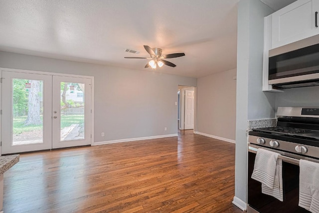 2218 Silverbonnet St, Houston, TX 77055 - kitchen featuring appliances with stainless steel finishes, wood finished floors, ceiling fan, french doors, and white cabinetry