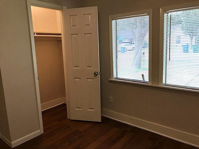 5734 Arthington St, Houston, TX 77053 - unfurnished bedroom with baseboards, dark wood-style flooring, a closet, and a walk in closet