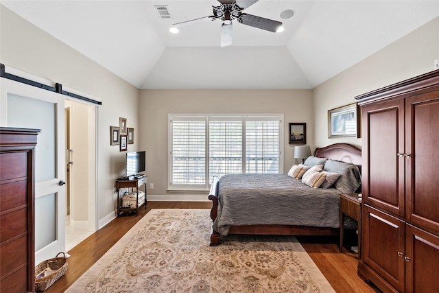 926 Grand Oaks Cir, College Station, TX 77840 - bedroom with wood finished floors, a barn door, a ceiling fan, and vaulted ceiling