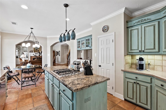 926 Grand Oaks Cir, College Station, TX 77840 - kitchen with arched walkways, stainless steel gas cooktop, a center island, backsplash, and a chandelier