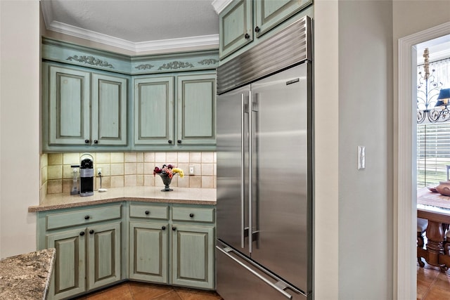 926 Grand Oaks Cir, College Station, TX 77840 - kitchen with stainless steel built in fridge, green cabinets, decorative backsplash, ornamental molding, and light tile patterned floors