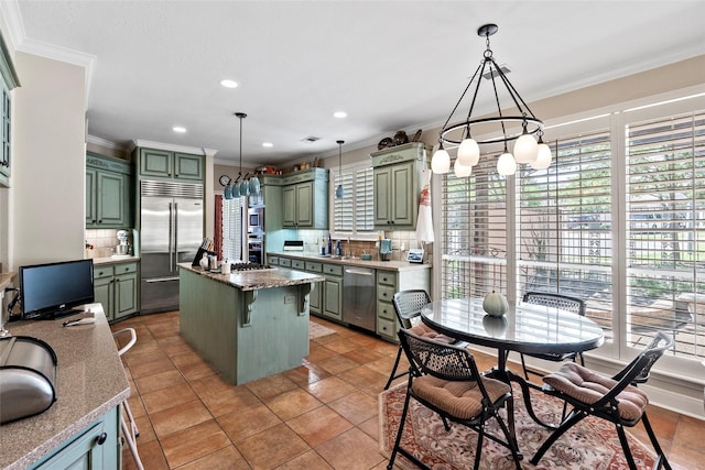 926 Grand Oaks Cir, College Station, TX 77840 - kitchen featuring green cabinetry, stainless steel appliances, crown molding, tasteful backsplash, and a center island