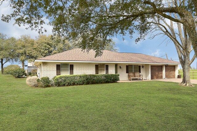 6720 Kacal Rd, Beasley, TX 77417 - ranch-style house featuring an attached garage, covered porch, a front lawn, brick siding, and driveway