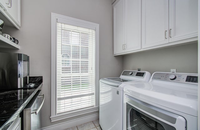 4516 Palmetto St, Bellaire, TX 77401 - washroom featuring independent washer and dryer, healthy amount of natural light, cabinet space, and light tile patterned flooring