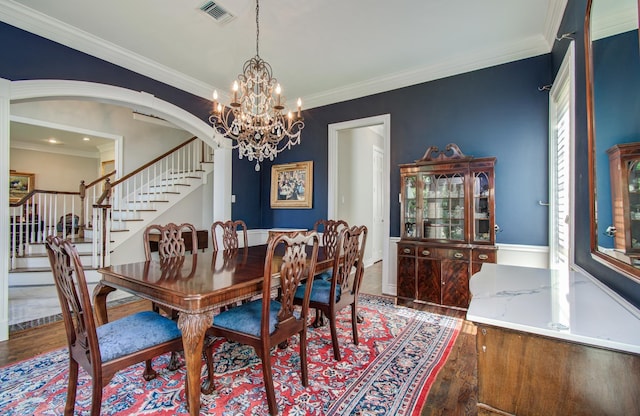 4516 Palmetto St, Bellaire, TX 77401 - dining room with stairs, wood finished floors, a chandelier, ornamental molding, and arched walkways