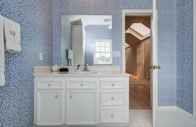 4516 Palmetto St, Bellaire, TX 77401 - bathroom with wallpapered walls, vanity, and baseboards