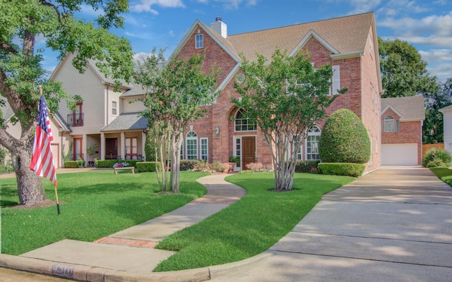 4516 Palmetto St, Bellaire, TX 77401 - view of front of home with brick siding, a chimney, a garage, and a front lawn