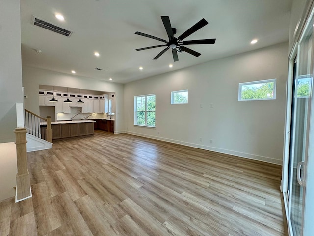 1637 Beall St, Houston, TX 77008 - unfurnished living room featuring light wood-type flooring, stairs, recessed lighting, and baseboards