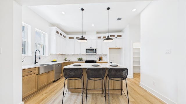 1637 Beall St, Houston, TX 77008 - kitchen featuring stainless steel appliances, light wood-type flooring, tasteful backsplash, and recessed lighting