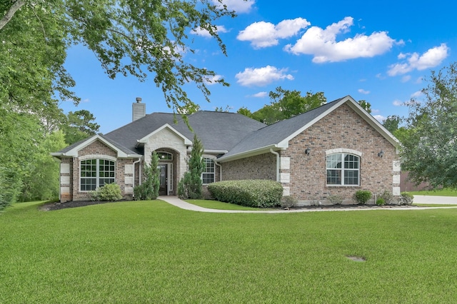 281 Berkley Dr, Montgomery, TX 77356 - view of front of house with a chimney, a front yard, and brick siding