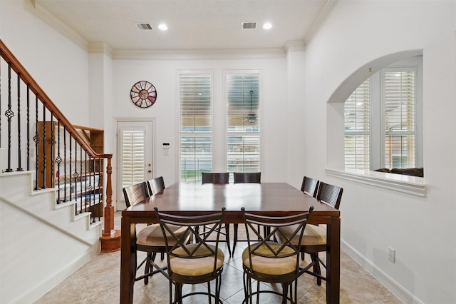 3602 Lindhaven Dr, Pearland, TX 77584 - dining room with crown molding, arched walkways, stairs, light tile patterned floors, and baseboards
