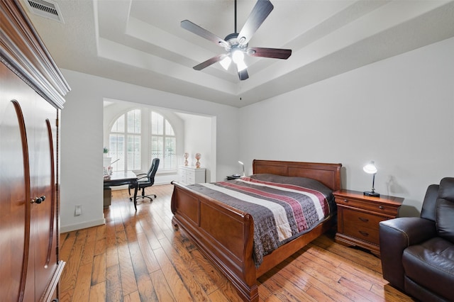 3602 Lindhaven Dr, Pearland, TX 77584 - bedroom with a raised ceiling, a desk, light wood-style flooring, baseboards, and ceiling fan