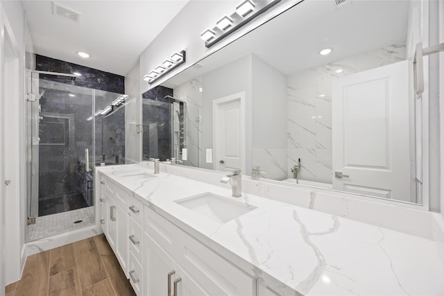 4923 Golden Forest Dr, Houston, TX 77091 - bathroom with double vanity, a marble finish shower, recessed lighting, and wood finished floors