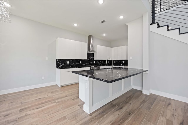 4923 Golden Forest Dr, Houston, TX 77091 - kitchen with wall chimney exhaust hood, light wood finished floors, white cabinetry, decorative backsplash, and recessed lighting