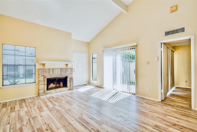 6103 Ludington Dr Unit 4-941, Houston, TX 77035 - unfurnished living room featuring beam ceiling, wood finished floors, high vaulted ceiling, baseboards, and a brick fireplace