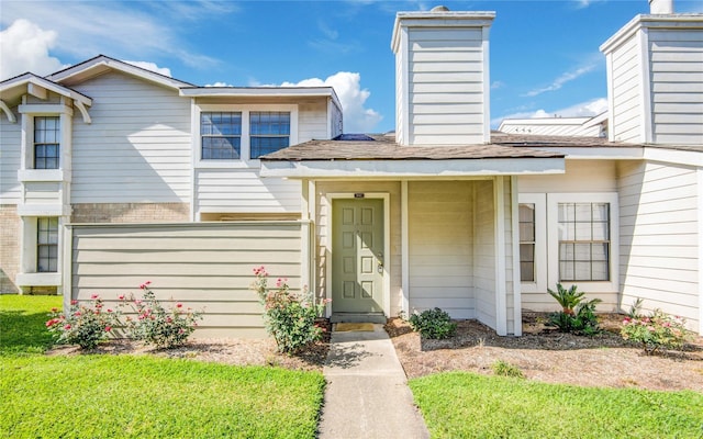 6103 Ludington Dr Unit 4-941, Houston, TX 77035 - view of front facade with a chimney, brick siding, and a shingled roof