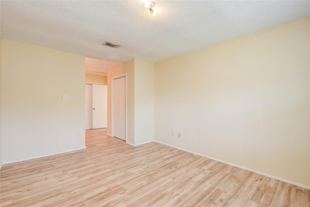 6103 Ludington Dr Unit 4-941, Houston, TX 77035 - empty room with light wood-style flooring, baseboards, and a textured ceiling