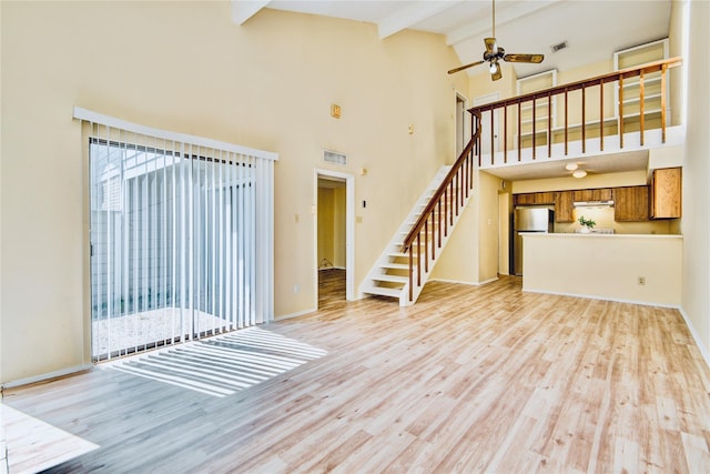 6103 Ludington Dr Unit 4-941, Houston, TX 77035 - unfurnished living room featuring stairway, light wood-style floors, beamed ceiling, high vaulted ceiling, and baseboards