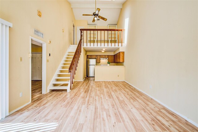 6103 Ludington Dr Unit 4-941, Houston, TX 77035 - unfurnished living room featuring high vaulted ceiling, light wood-style floors, a ceiling fan, stairway, and baseboards