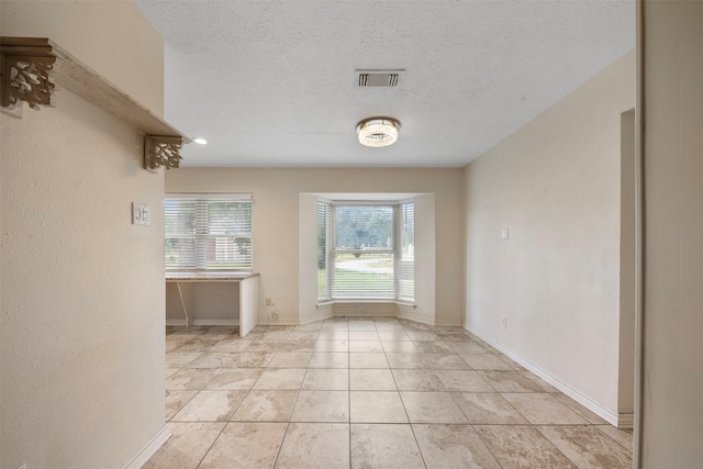 31302 Wisteria Rd, Magnolia, TX 77355 - unfurnished dining area featuring light tile patterned flooring and a textured ceiling