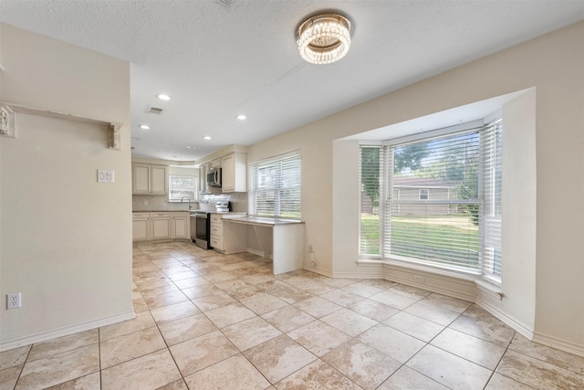 31302 Wisteria Rd, Magnolia, TX 77355 - kitchen with stainless steel appliances, backsplash, recessed lighting, light tile patterned flooring, and light countertops