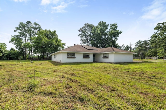 31302 Wisteria Rd, Magnolia, TX 77355 - rear view of house with solar panels, a yard, and stucco siding