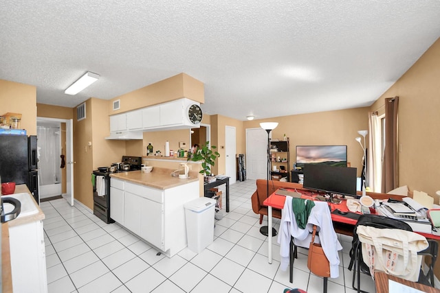 2750 Holly Hall St Unit 1104, Houston, TX 77054 - kitchen featuring black appliances, under cabinet range hood, light countertops, a textured ceiling, and white cabinets