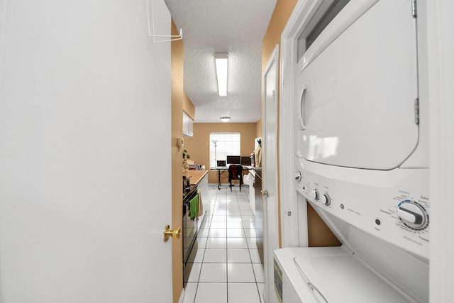 2750 Holly Hall St Unit 1104, Houston, TX 77054 - laundry area with stacked washer / drying machine, light tile patterned floors, and a textured ceiling