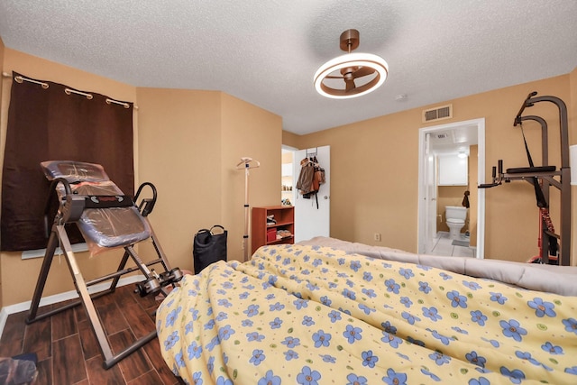 2750 Holly Hall St Unit 1104, Houston, TX 77054 - bedroom with a textured ceiling, wood finished floors, baseboards, and connected bathroom