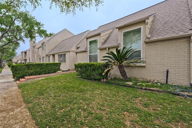 6493 Alisa Ln, Houston, TX 77084 - view of front facade featuring brick siding, a front lawn, and roof with shingles