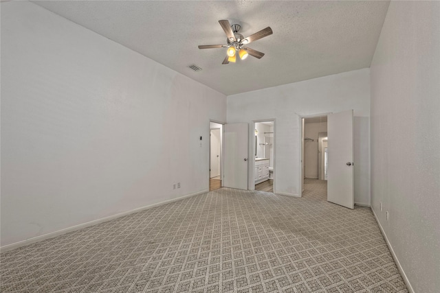 6493 Alisa Ln, Houston, TX 77084 - unfurnished bedroom with baseboards, ensuite bathroom, a textured ceiling, a ceiling fan, and light colored carpet
