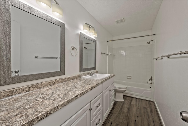 6493 Alisa Ln, Houston, TX 77084 - bathroom featuring wood finished floors, vanity, toilet, shower / bath combination, and a textured ceiling