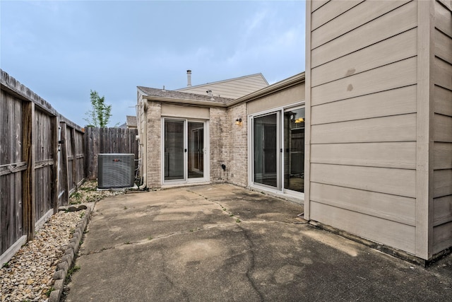 6493 Alisa Ln, Houston, TX 77084 - rear view of house featuring central air condition unit, a patio, a fenced backyard, and brick siding